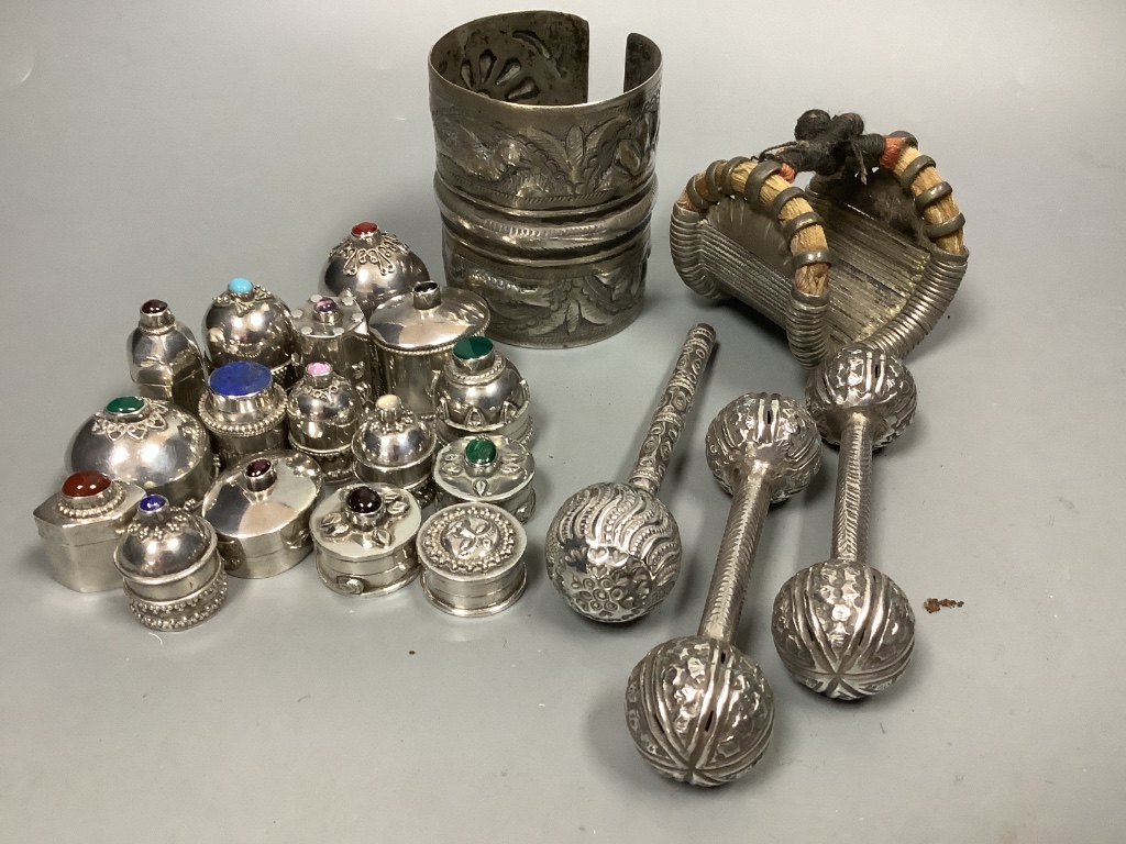 Sixteen Omani decorative silver trinket boxes, inset various semi-precious stones, a wide embossed bangle, a pair of 'cuff' bangles and three other items